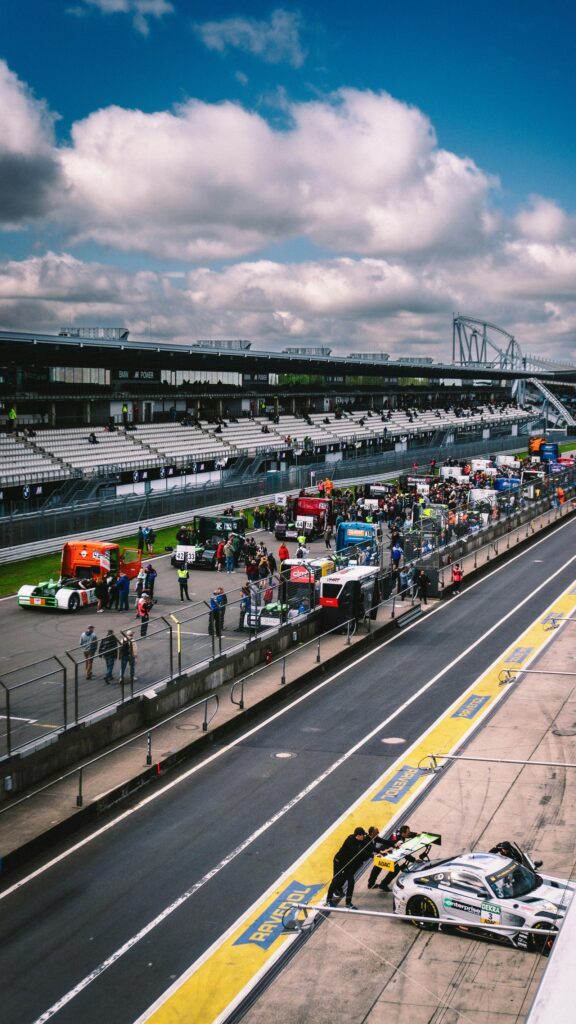 High-Octane Nürburgring Pit Lane Action Mobile Wallpaper