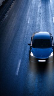 Tesla Model 3 Driving on Wet Highway at Night Mobile Wallpaper