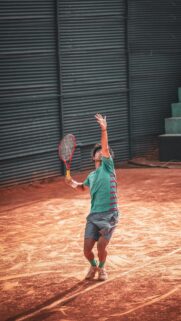 Tennis Player Serving on Clay Court Action Mobile Wallpaper
