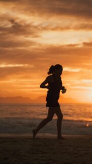 Woman Running on Beach at Sunset Mobile Wallpaper