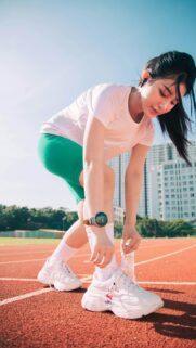 Athletic Girl Tying Shoelaces on Running Track Phone Wallpaper