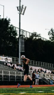 Female Soccer Player Throw-In Action on Sports Field Wallpaper