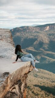 Woman Sitting on Mountain Cliff Edge Scenic Nature Wallpaper