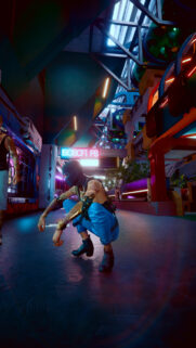 Cyberpunk Street Style Character Crouching in Neon City Wallpaper