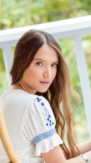 Stunning Portrait of a Young Woman with Long Brown Hair in a White Embroidered Blouse