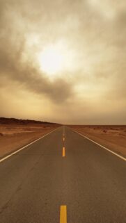 Endless Desert Highway Under Golden Sunset Sky Mobile Wallpaper