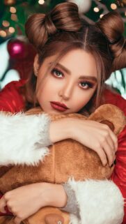 Beautiful Girl with Space Buns Holding a Teddy Bear Christmas Wallpaper