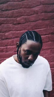 Kendrick Lamar Portrait Against Red Brick Wall Mobile Wallpaper