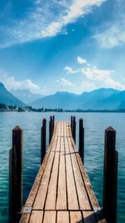 Stunning Wooden Pier Over Serene Blue Lake with Mountain Views Mobile Wallpaper