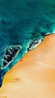 Stunning Aerial View of Turquoise Ocean Waves Meeting Golden Sand Desert Wallpaper
