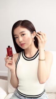 Stunning Asian Model Using Chanel Skincare Serum Portrait Wallpaper