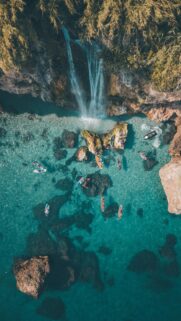 Stunning Aerial View of Tropical Waterfall and Kayakers Wallpaper