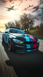 BMW M4 Safety Car Driving Fast at Sunset Wallpaper for Mobile