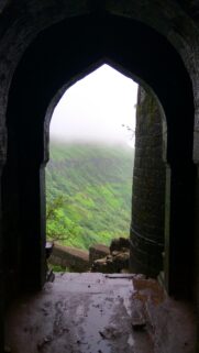 Ancient Stone Archway Opening to Misty Green Mountain Landscape Wallpaper