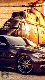 Stunning Luxury Sports Car with Helicopter Background Wallpaper