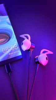 Modern Neon Tech Setup Wallpaper with Smartphone and Earphones in Vibrant Purple and Blue Lighting