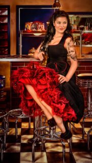 Vintage Pinup Girl in Red and Black Dress at Retro Diner Wallpaper