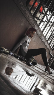 Sad Red Haired Woman Sitting in Dark Industrial Room 4K Mobile Wallpaper