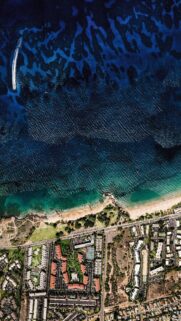 Stunning Aerial View of Tropical Coastal City and Deep Blue Ocean Wallpaper