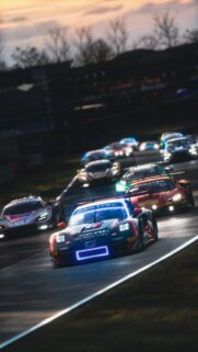 High Speed GT3 Racing Cars on Track at Sunset Mobile Wallpaper
