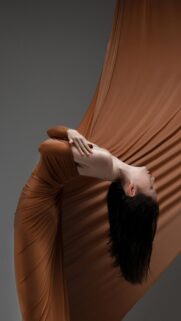 Elegant Woman in Brown Silk Dress Artistic Pose Wallpaper