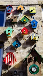 Colorful Whimsical Birdhouses on Stone Wall High Resolution Wallpaper