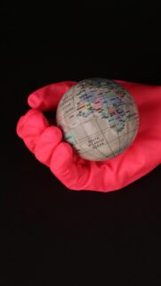Conceptual Earth Held by Red Rubber Glove Premium Mobile Wallpaper
