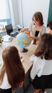 Teacher and Students Studying Globe Classroom Education Wallpaper