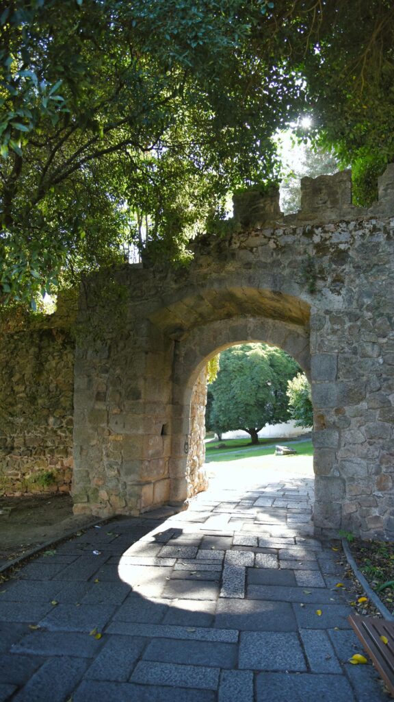 Ancient Stone Archway in a Sunlit Garden Mobile Wallpaper