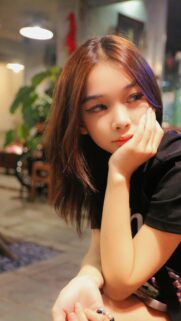 Beautiful Asian Girl Resting Chin on Hand Portrait Mobile Wallpaper
