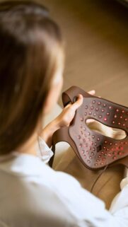 Woman Holding Red Light Therapy LED Skincare Mask Wallpaper