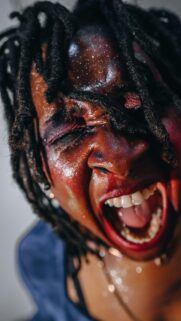 Intense Dramatic Portrait with Red Makeup and Dreadlocks Wallpaper