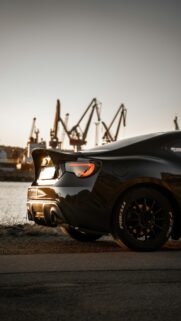 Black JDM Sports Car at Harbor Sunset Mobile Wallpaper