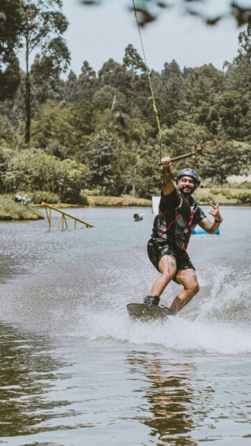 Thrilling Wakeboarder Mid-Action on Lake High Quality Mobile Wallpaper