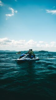Thrilling Jet Ski Adventure on Turquoise Ocean Waves Mobile Wallpaper