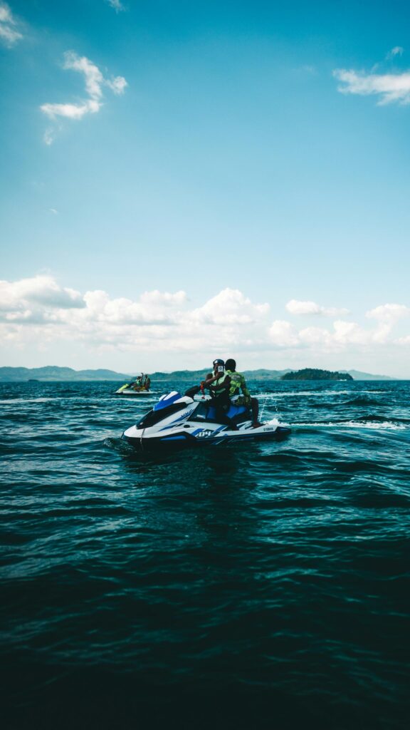 Thrilling Jet Ski Adventure on Turquoise Ocean Waves Mobile Wallpaper