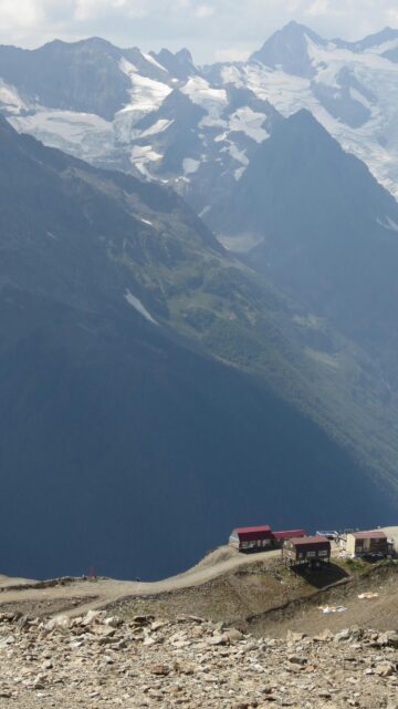 Breathtaking Alpine Mountain Peaks with Remote Cabin Village Wallpaper