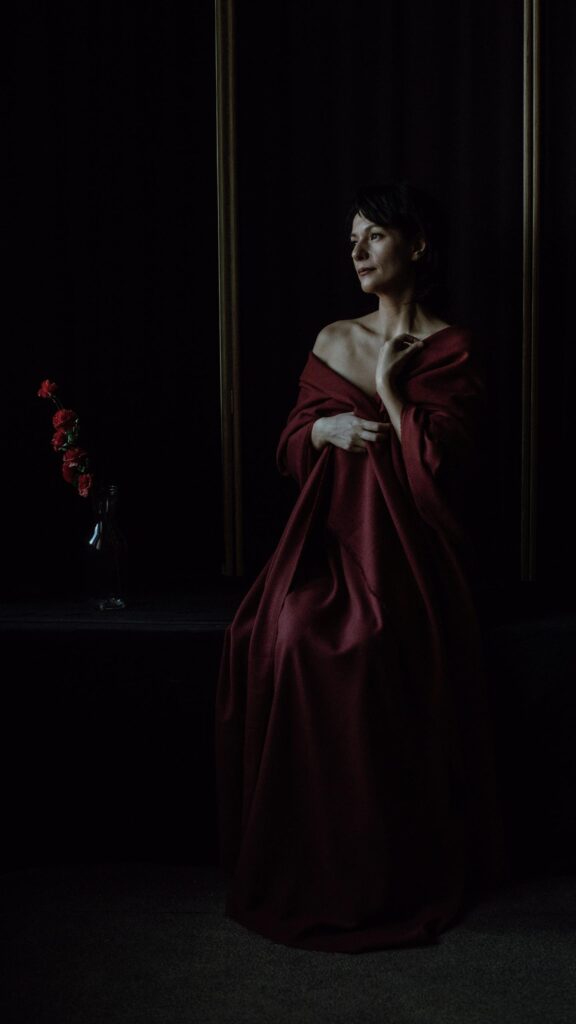 Elegant Woman in Deep Red Drape Portrait 4K Mobile Wallpaper