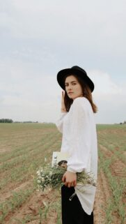 Woman with Wildflowers and Hat in Field Mobile Wallpaper