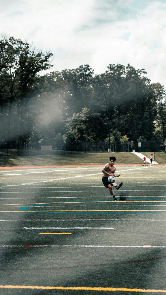Shirtless Soccer Player Training on Turf Field Mobile Wallpaper