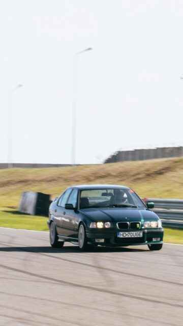 Dark Green BMW E36 Racing Sedan on Racetrack Mobile Wallpaper