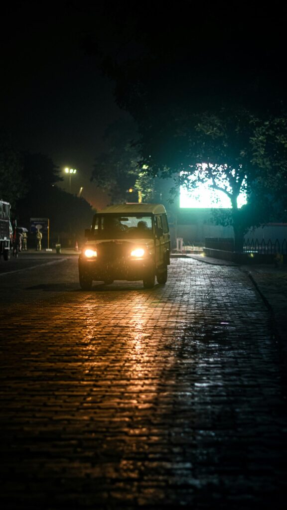 Moody Night Drive SUV on Cobblestone Street Mobile Wallpaper