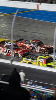 NASCAR Truck Racing Action with High Speed Trucks Wallpaper