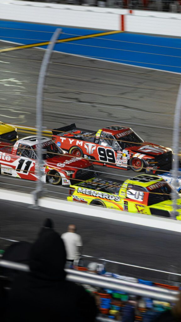 NASCAR Truck Racing Action with High Speed Trucks Wallpaper