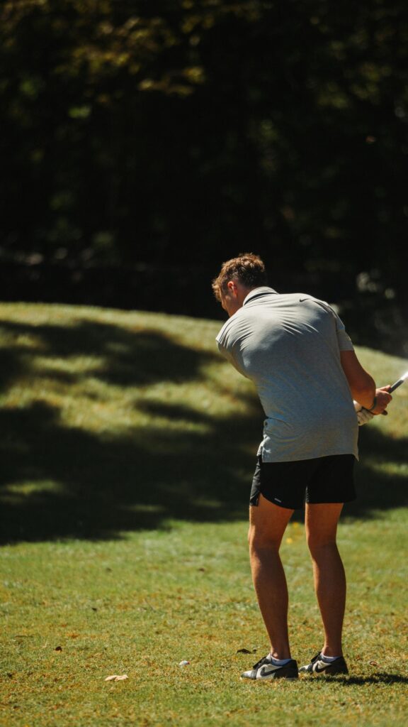 Golfer Taking a Powerful Swing on a Sunny Course Mobile Wallpaper