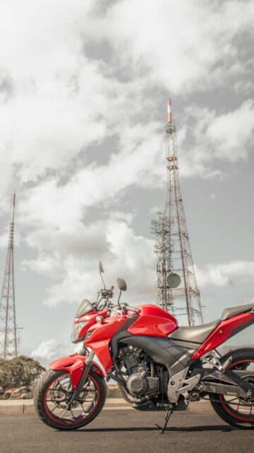 Red Honda CB500 Motorcycle Under Radio Towers Mobile Wallpaper