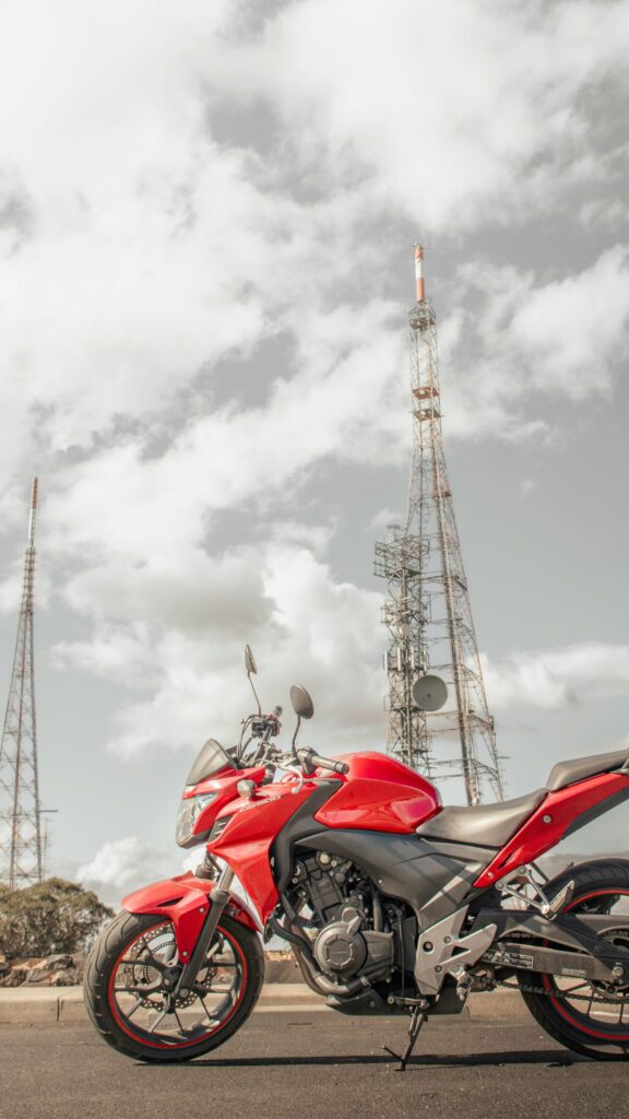 Red Honda CB500 Motorcycle Under Radio Towers Mobile Wallpaper