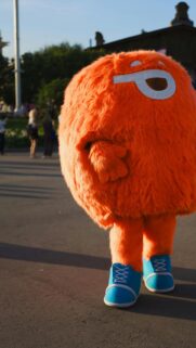 Cute Orange Furry Mascot Character Wearing Blue Sneakers Wallpaper