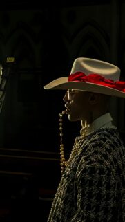 Stylish Man in Cowboy Hat with Rosary Moody Aesthetic Phone Wallpaper