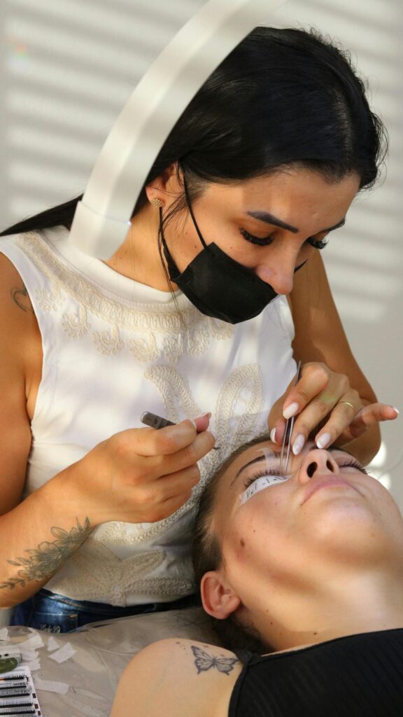 Professional Eyelash Extension Technician Working Close-up Wallpaper
